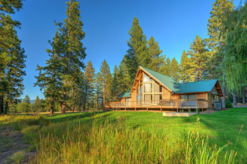 luxury cedar cabin home with large pine tree and pond