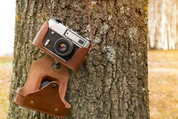 Old camera hanging on a tree