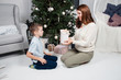 © queen1987 - Smiling baby boy gave Christmas present to mom