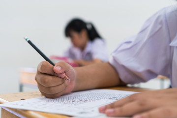 Wall Mural - students hands taking exams, writing examination room with holding pencil on optical form of standar