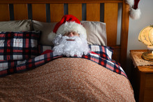 Santa Claus Sleeping In His Bed At The North Pole After His Christmas Eve Deliveries, With His Beard Outside The Covers.