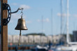 bell in the port with shapes of boats in the background