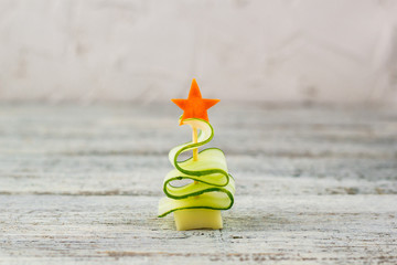 Creative christmas tree of cucumber, cheese and star of carrot. Funny kids food for new year party