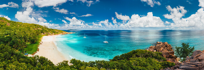 aerial pano of grand anse beach at la digue island in seychelles. white sandy beach with blue ocean 