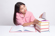 © halfbottle - Young Asian woman read a book with books on table.