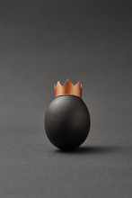 Black Painted Vertical Imperial Easter Egg In A Golden Crown On A Black Background.