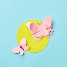 Handmade Paper Pink Butterflies On A Yellow Round Frame On A Light Blue Background With Copy Space. Flat Lay