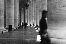 Unidentified Man Passes By The Columns Of The Vatican Square