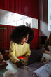 © MyMicrostock/Stocksy - Afro casual woman using laptop in meeting room