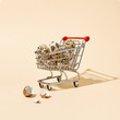 © Yaroslav Danylchenko/Stocksy - Quail eggs in a shopping cart and broken shells on a beige background with copy space. Concept of financial loss