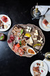© ANDREW CEBULKA/Stocksy - Charcuterie plate on wooden platte with drinks