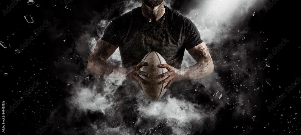 Rugby player in action on dark - obrazy, fototapety, plakaty 