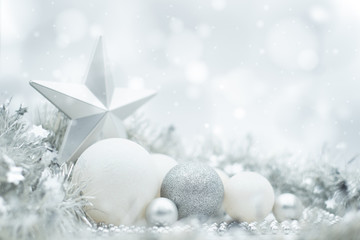 a festive design of silvery and white christmas ornaments under a winter effect bokeh and snow backg