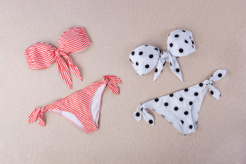 red and white striped sita bikini and black and white polka dot bikini isolated on textured background