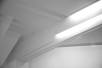 Poster - Glowing girders under ceiling. Abstract architecture fragment. Modern office building interior with white polygonal concrete structure. Diagonal geometric composition, Construction in gray halftones.