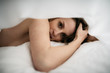 © Chris Zielecki/Stocksy - Young naked female lying on bed under blanket
