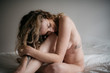© Chris Zielecki/Stocksy - Naked woman with closed eyes posing on bed