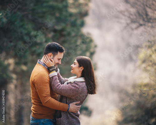 Fotografía Beautiful young couple embracing and caressing on a path through forest