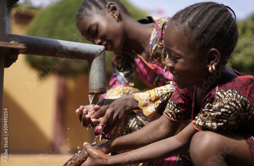 Cuadros en Lienzo Two Gorgeous African Children Girls Drinking Freshwater in Bamako, Mali
