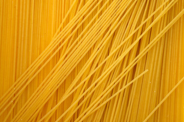 Thin spaghetti background top view. Uncooked raw spaghetti.