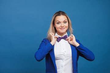 Wall Mural - Happy smiling young woman in blue on blue background. Friendly business portrait