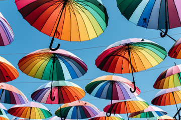 Umbrellas in rainbow color on blue sky background