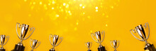Champion Cups On Yellow Background With Sparkling Lite. Tha Winner Takes It All!