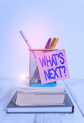 Word writing text What S Next Question. Business photo showcasing asking demonstrating about his coming actions or behaviors Stacked books pens metal holder sticky note lying vintage old wooden table