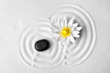 Zen garden. Beautiful lotus flower and stone on white sand, flat lay