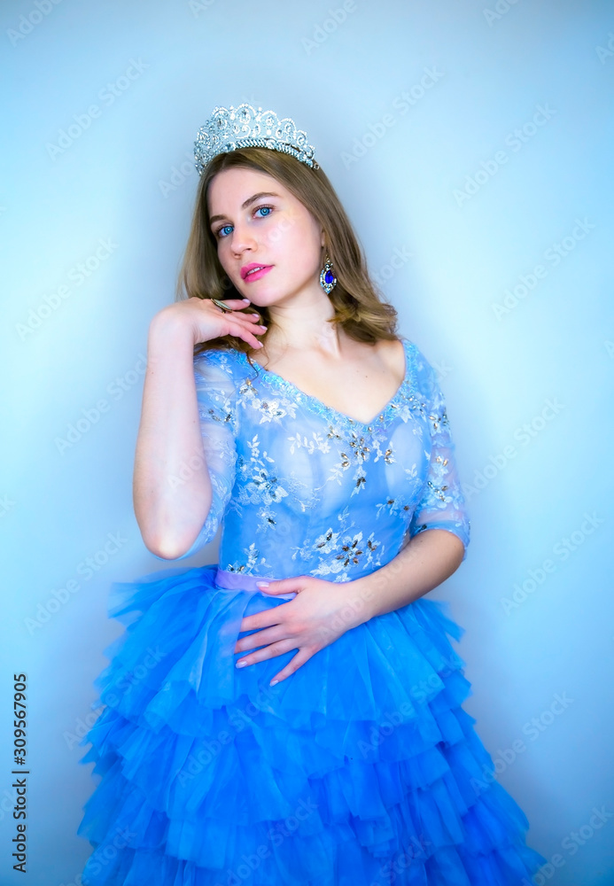 Young beautiful girl with blue eyes in a blue festive dress. Girl with ...