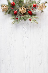 fir branch with christmas decoration on white shabby wooden board with copy space for text. flat lay