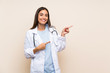 © luismolinero - Young doctor woman over isolated background pointing finger to the side