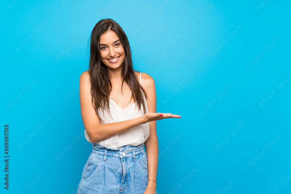 Young woman over isolated blue background smiling with a happy and pleasant expression - obrazy, fototapety, plakaty 