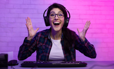 Happy esport female gamer playing online game on computer