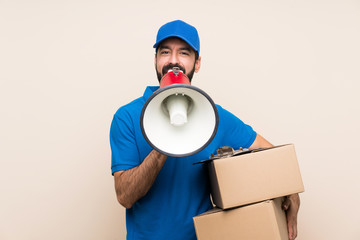 Wall Mural - Delivery man with beard over isolated background shouting through a megaphone