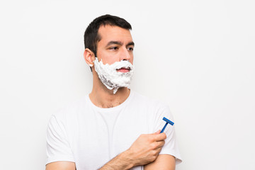 Man shaving his beard over isolated white background portrait