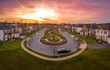 Aerial sunset view of luxury upscale residential neighborhood circle street with a lake view in Maryland USA, American real estate with single family homes brick facade colorful sky gated community