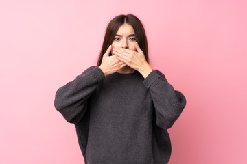 Wall Mural - Young woman over isolated pink background covering mouth with hands