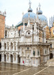 Doge`s Palace or Palazzo Ducale, Venice, Italy. It is famous landmark of Venice. Ornate facade of Doge`s Palace and domes of St Mark`s Basilica behind it.