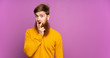 © luismolinero - Redhead man with long beard over isolated purple background surprised and shocked while looking right