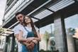 Half length portrait of handsome Caucasian hipster guy embracing young wife during journey adventure for exploring new city, positive couple in love hugging outdoors during recreation time