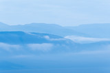 Fototapeta Łazienka - Gentle hills in bluish haze. Soft light in early morning, silhouettes of mountains