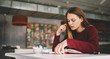 © GalakticDreamer - Concentrated female student sitting at cafeteria reading interesting book for literature homework task , young contemplative serious girl studying and searching information at university library