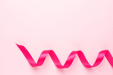 Wall Mural - Gift ribbon fuchsia color on pink background. Minimalistic composition for the holidays.