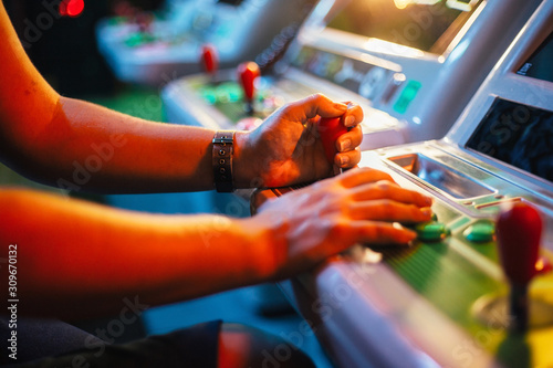 Fotografía Detail on hands playing with joystick on old vintage arcade game in a dark room