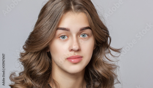 Fotografía Portrait of a beautiful happy woman with curly hair, clean skin and thick eyebrows beauty salon