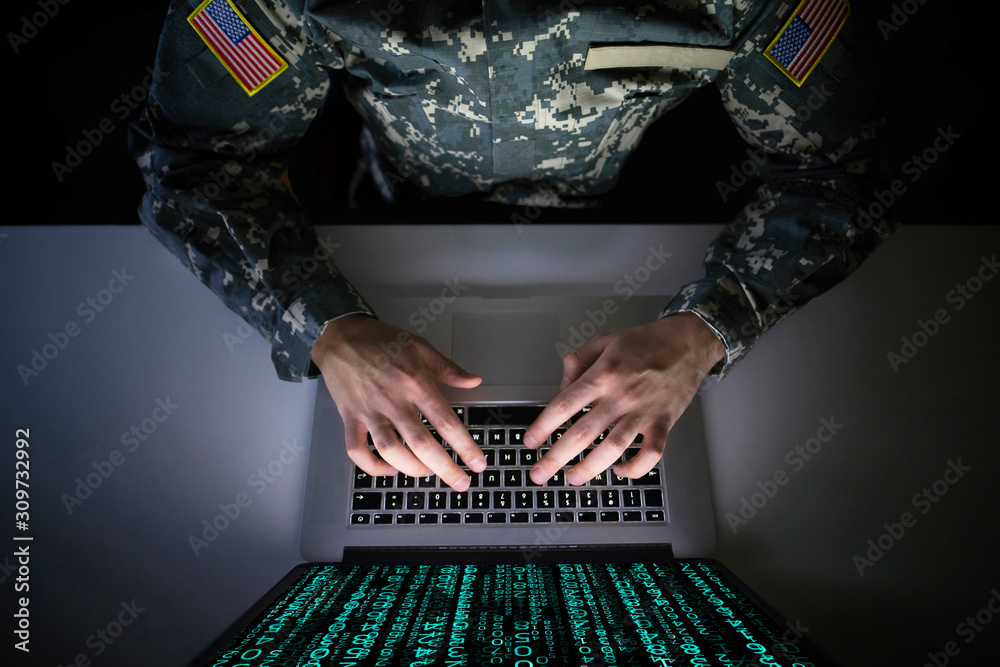 American soldier in military uniform preventing cyber attack in military intelligence center. An US officer intercepting messages to stop terrorism. Modern warfare system surveillance concept. - obrazy, fototapety, plakaty 