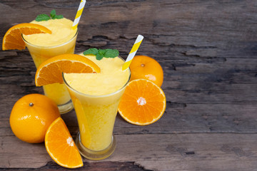 Orange juice fruit smoothies yogurt drink yellow healthy delicious taste in a glass slush for weight loss on wooden background.