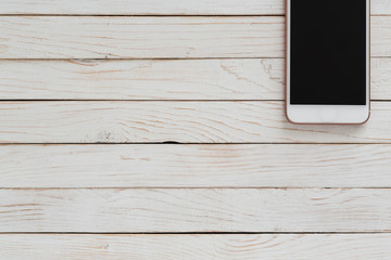 white smartphone iphone with dark screen on white wood texture background