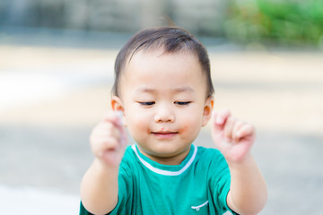 Wall Mural - Motor skills and Fine Motor Skills Concept.Little baby boy child showing hands when he play sand in playground park.Child development concept.